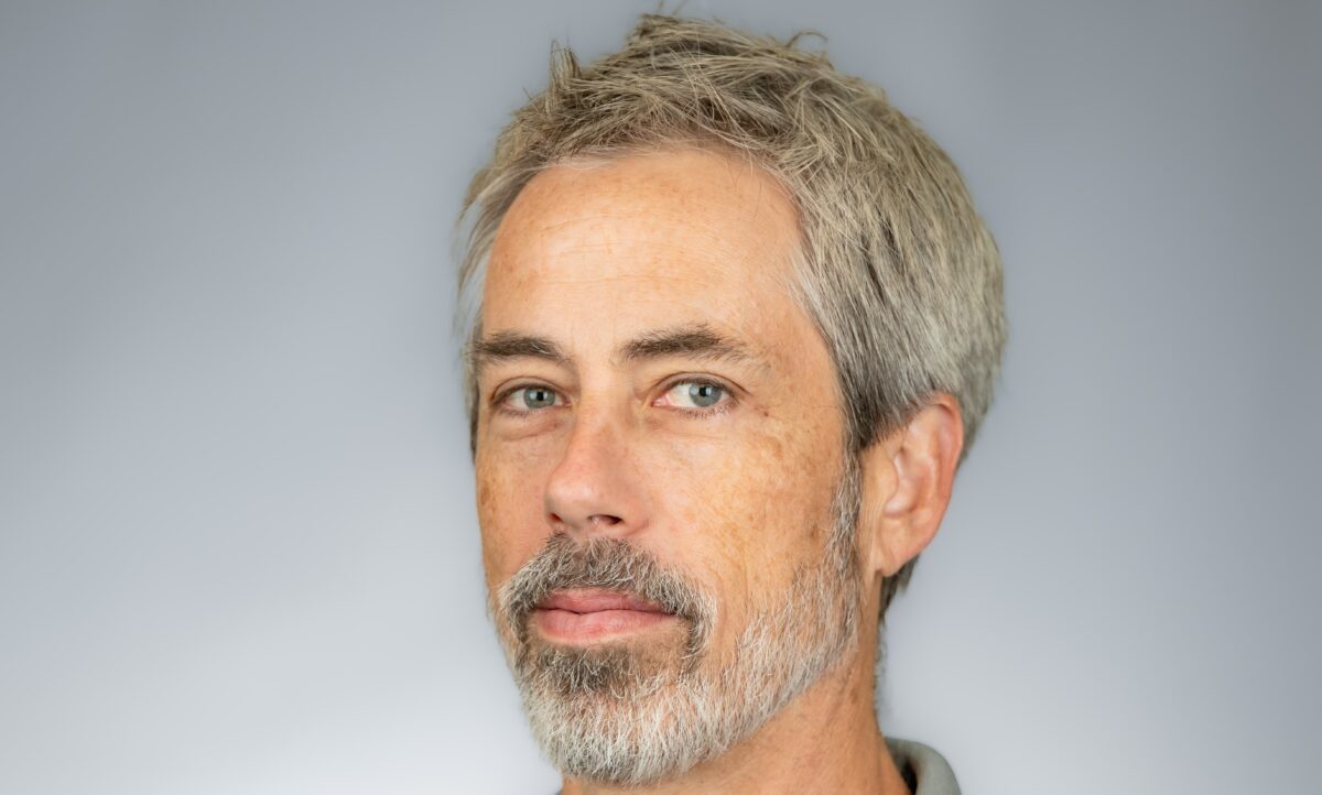 Professional photo of Jason Nauyalis for Meet the Team with gray shirt and green background