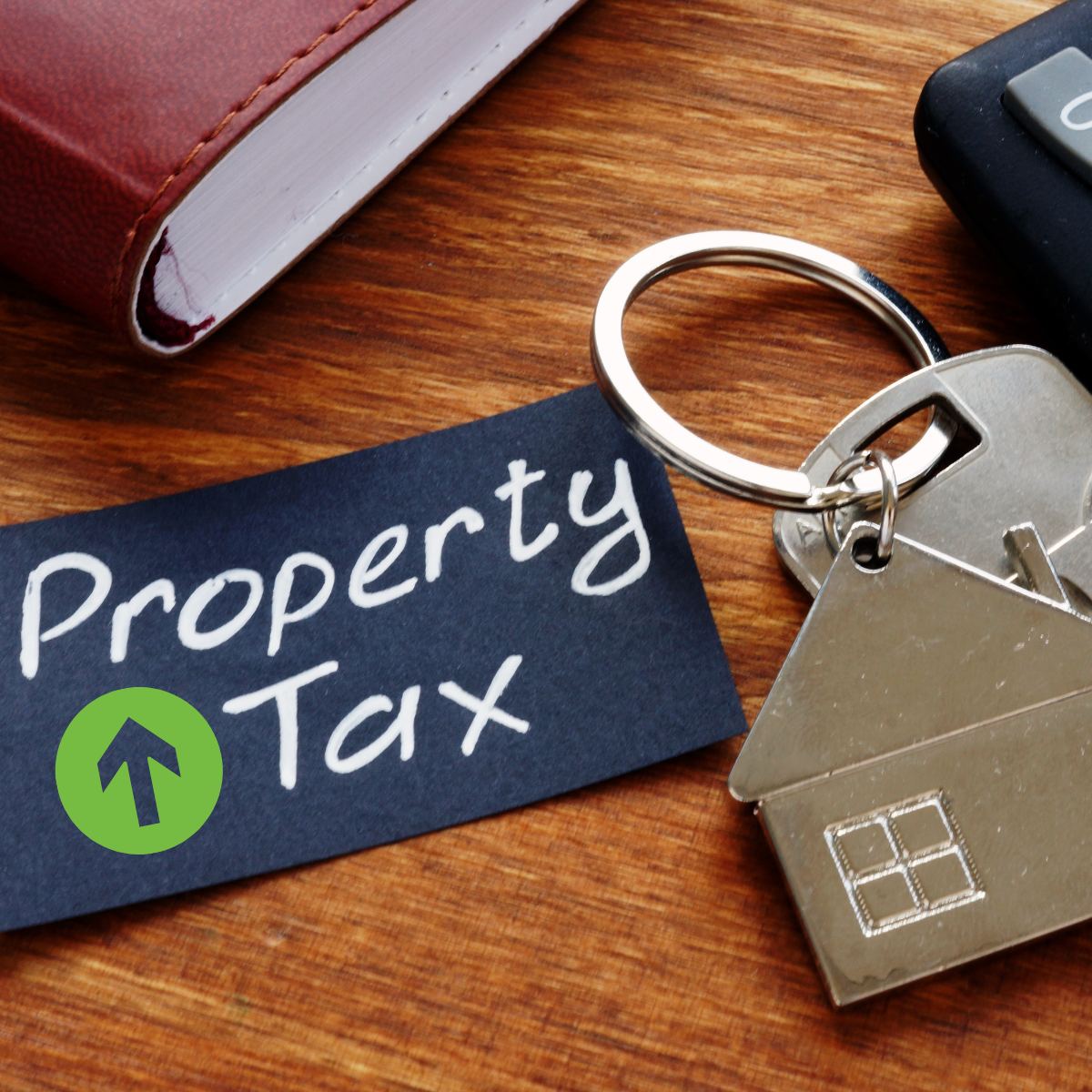 Image of key with house keychain, note that says property tax and book edge