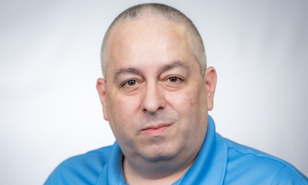 Photo of Ron with blue shirt and navy overlay over photo with green background