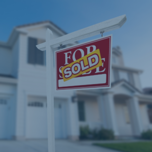 Two-story house with for sale sign in front with word sold across sign