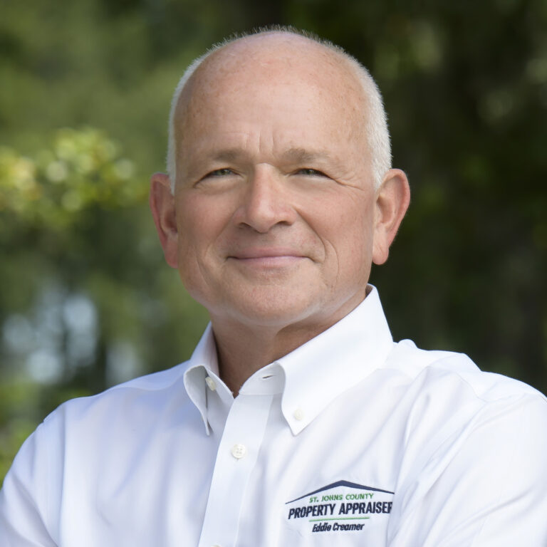 Photo of Eddie with white shirt and green tree trees in background