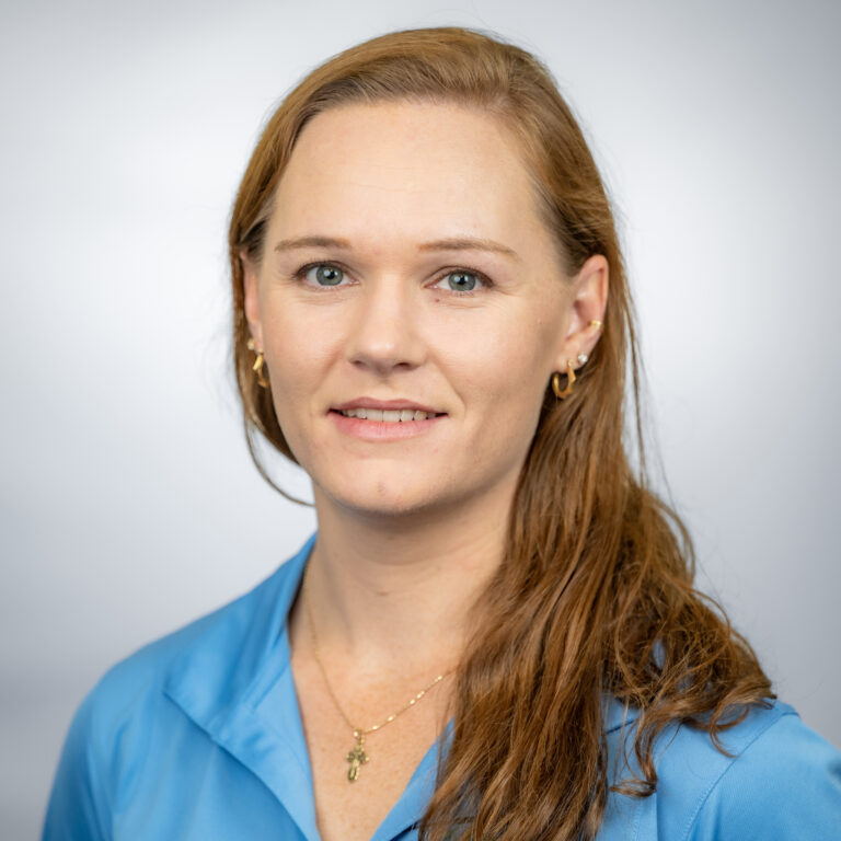 Photo of Loren with blue shirt and gray background