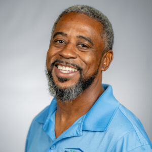 TJ with blue shirt and gray background